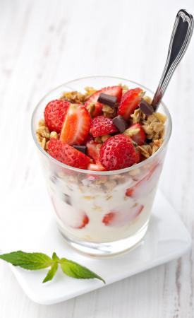Dobrym pomysłem na drugie śniadanie jest jogurt naturalny z owocami, płatkami oraz odrobiną gorzkiej czekolady.