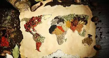 Map of world made from different kinds of spices on wooden background