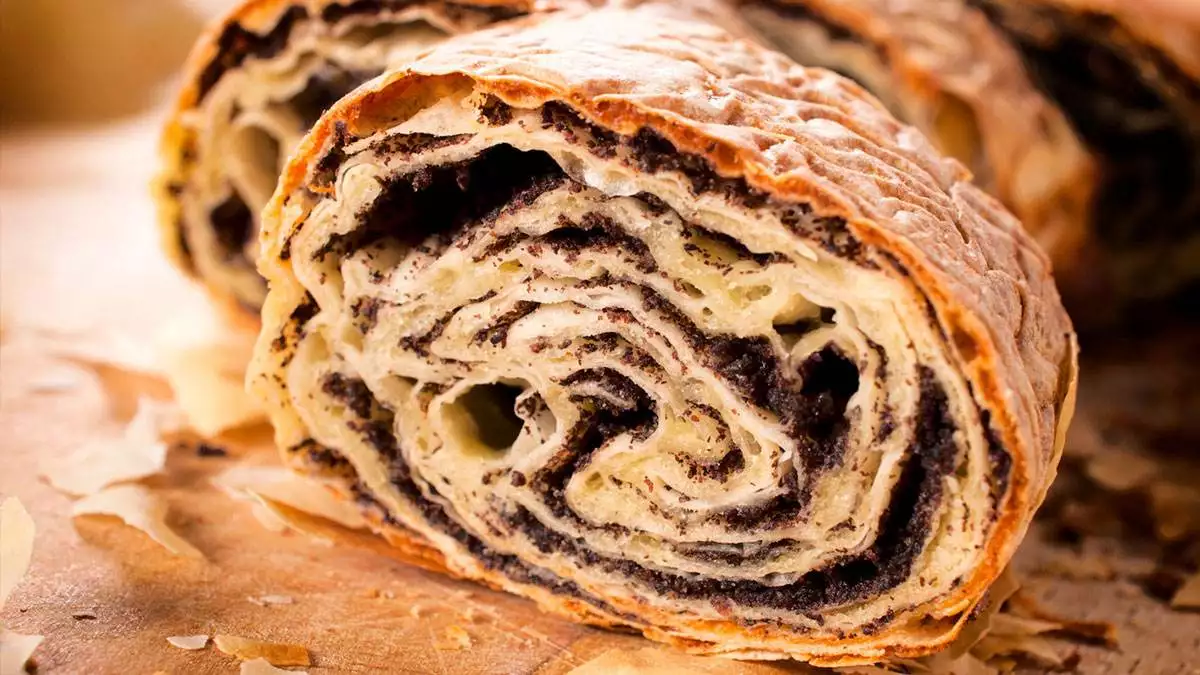 Strudel makowy na drewnianej desce.