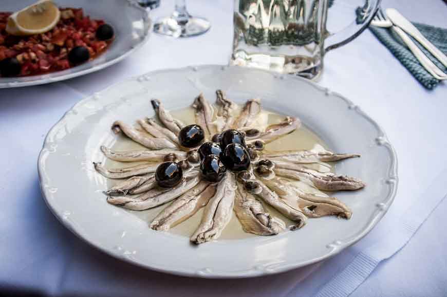 Talerz z przystawką z anchois i oliwkami.
